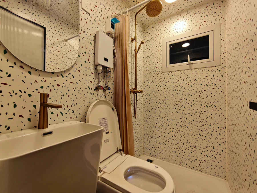 10ft expandable container house bathroom with terrazzo walls and gold-finish fixtures