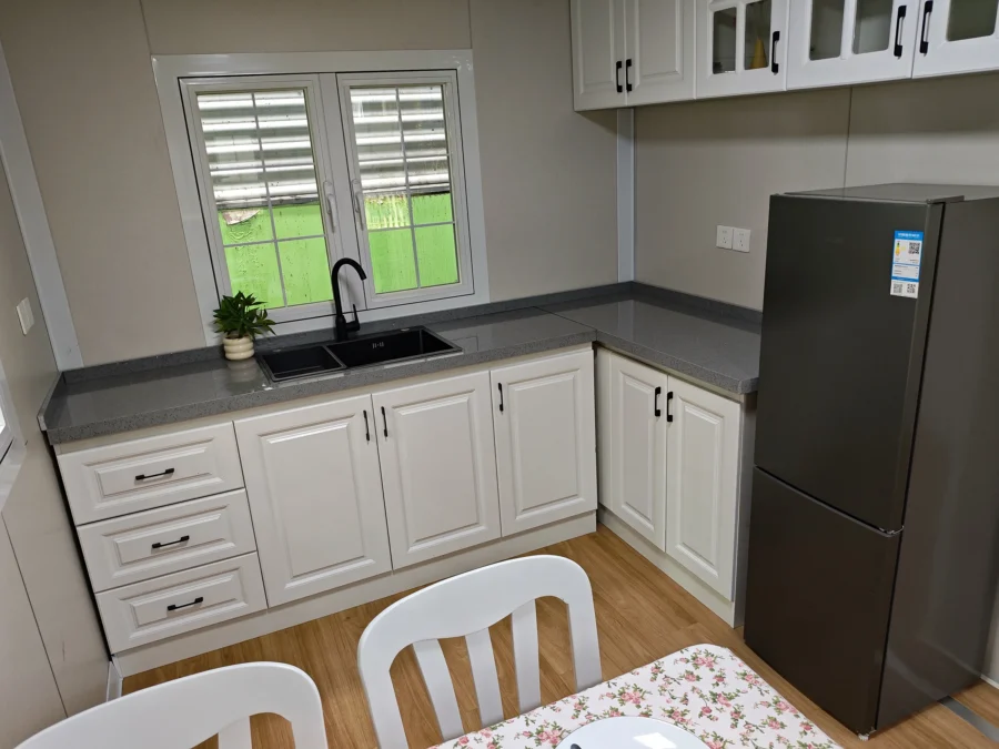20ft container house interior with white country-style kitchen and dining area