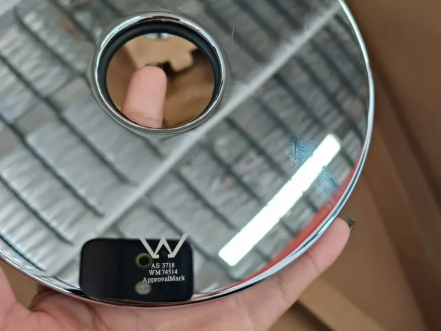 Hand holding a faucet bearing the WaterMark certification mark