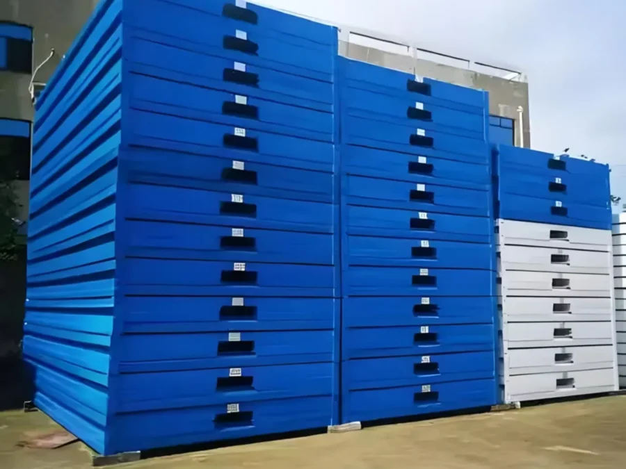 Blue flat-pack container house units stacked for bulk transport