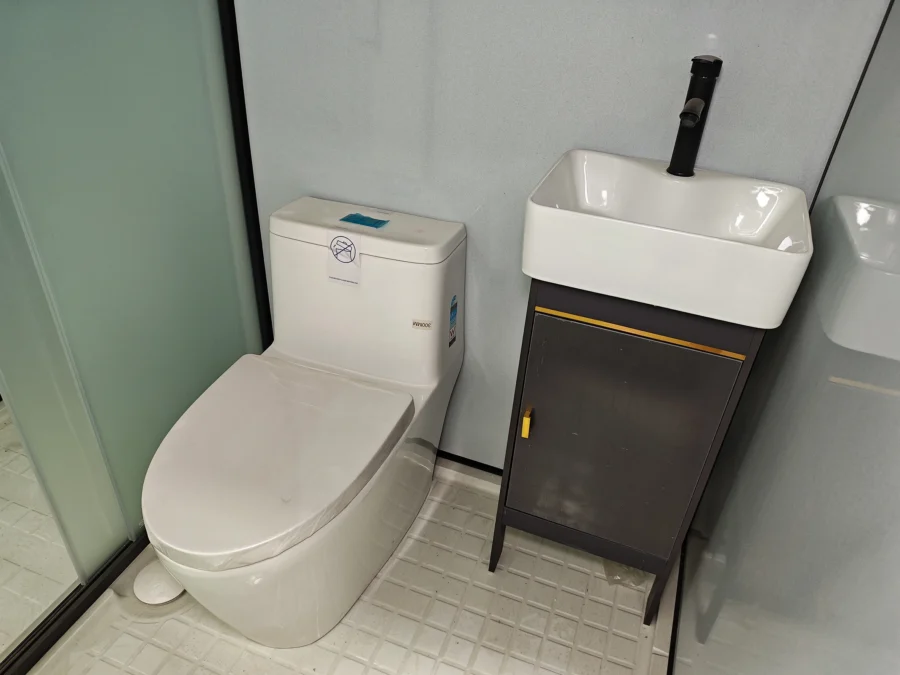 Modular bathroom pod toilet and black-trim vanity cabinet